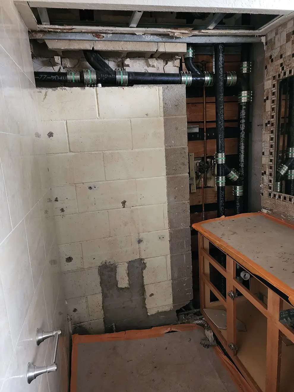 Bathroom under renovation with exposed plumbing